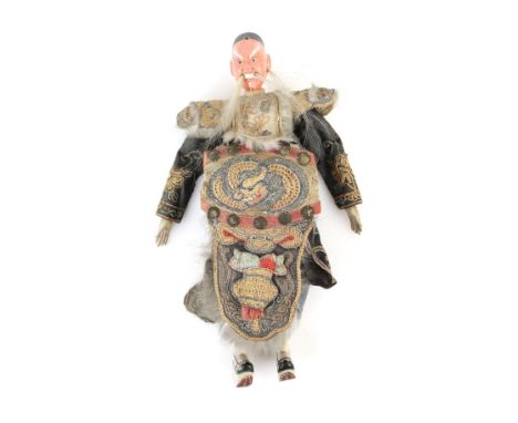 A Manchu/Chinese doll with wooden head and feet, detachable head dress, hair moustache and embroidered clothing; 27 cm high; 