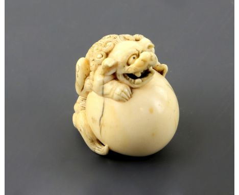 An ivory netsuke of a Karashishi on a large ball, unsigned, 19th CenturyPLEASE NOTE: THIS ITEM CONTAINS OR IS MADE OF IVORY. 