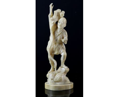 Late 19th/early 20th century Japanese carved ivory figure of a man with a long staff standing on a rock, signature to base, 1