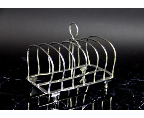 A silver six division toast rack, Charles Aldred Alston, London 1918, of plain form, raised on four bracket feet and with cen