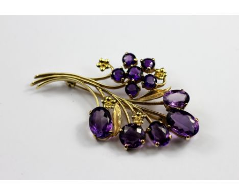 A 9ct yellow gold and amethyst spray brooch, the 9ct yellow gold floral brooch set with eleven amethysts, makers mark 'S & Co