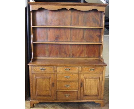 A George III design oak dresser, with an arrangement of six drawers and two cupboard doors on bracket feet, 189 x 137 x 41cm