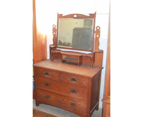 An Arts and Crafts oak dressing table - probably Liberty & Co, with rectangular mirror above two short and two long drawers o