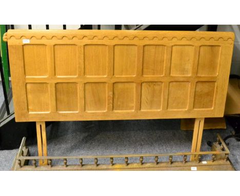 A Robert ''Mouseman'' Thompson oak 4ft 6'' panelled divan headboard, with castellated top, medium fumed, with carved mouse si