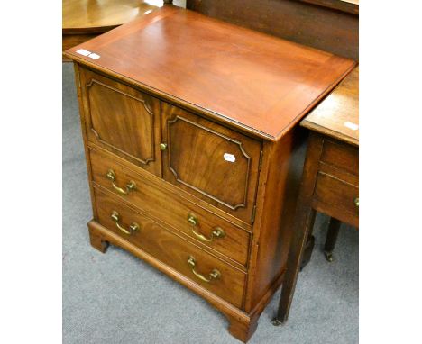 A George III style mahogany commode with a cupboard over two drawers 