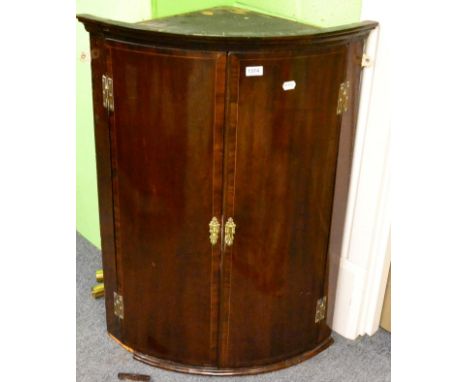 A 19th century cross banded mahogany bow fronted hanging corner cupboard