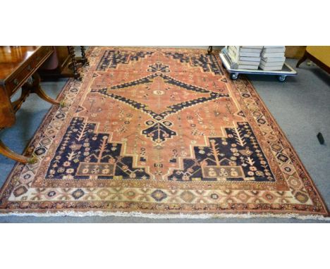 A West Iranian village carpet, the field with central stepped medallion framed by spandrels and ivory borders, 313cm by 222cm