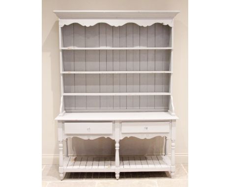 A Victorian style painted pine dresser, 20th century, with a moulded cornice over a shaped frieze and three enclosed shelves,