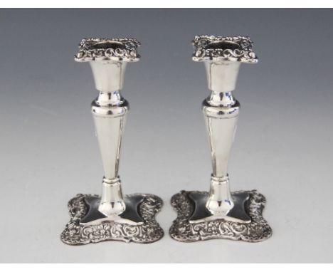 A pair of late Victorian silver candlesticks, William Devenport, Birmingham 1900, each with plain polished tapering stems, th