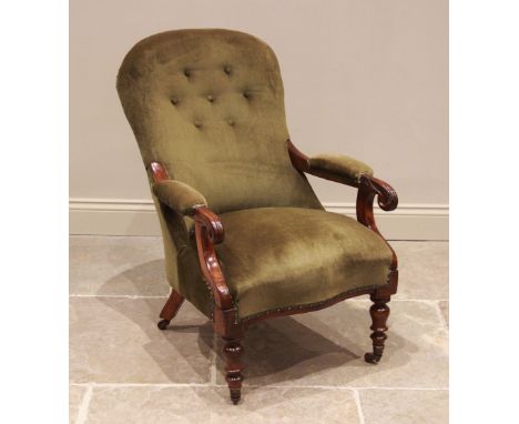 A Victorian mahogany and upholstered open armchair, the button back extending to padded arms with carved scroll terminals abo