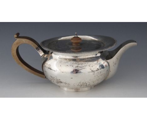 A George V silver teapot, Vander & Hedges, London 1918, of compressed spherical form on circular foot, wooden knop and handle