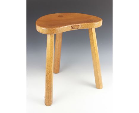 A Robert 'Mouseman' Thompson of Kilburn golden oak milking stool, mid 20th century, the kidney shaped seat carved with a trad