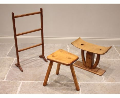 An African carved hardwood Ashanti stool, 20th century, the concave seat raised upon a central pillar and two curved supports