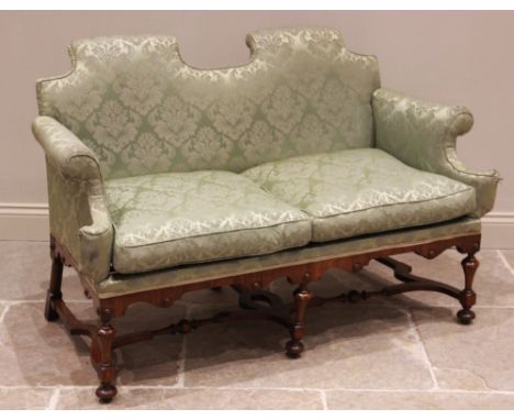 A William and Mary style walnut and upholstered settee, late 19th/early 20th century, in green satin fabric, the twin arched 