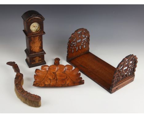 An early 20th century carved oak folding book trough, the two folding end supports carved as openwork foliate panels within a