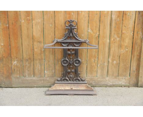 A Victorian Coalbrookdale style cast iron stick stand, the angular top rail upon a cast openwork upright and a conforming low