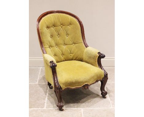 A Victorian mahogany framed tub style drawing room chair, the arched button back extending to padded arms with carved scrolle