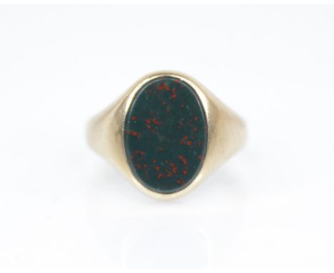 A 9ct gold bloodstone set signet ring, the oval plain polished bloodstone matrix measuring 13.2mm x 9.8mm, bezel set in 9ct y