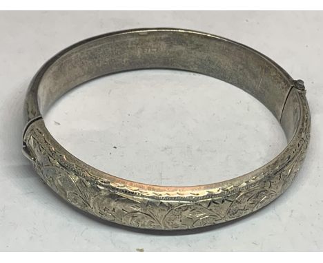 A HALLMARKED BIRMINGHAM WIDE SILVER BANGLE WITH AN ORNATE ENGRAVED DESIGN 