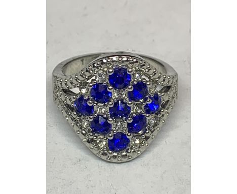 A SILVER DESIGNER DRESS RING WITH BLUE AND CLEAR STONES IN A DIAMOND DESIGN SIZE R 