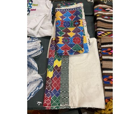 A QUANTITY OF BRIGHTLY COLOURED TEXTILES 