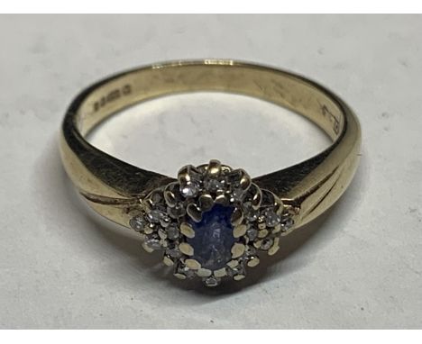 A 9 CARAT GOLD RING WITH A LIGHT BLUE STONE AND DIAMONDS IN A CLUSTER DESIGN SIZE L/M WITH A PRESENTATION BOX 