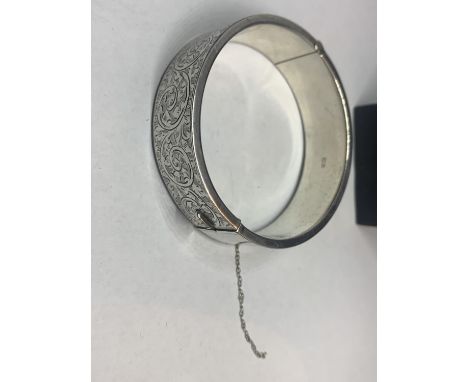 A HALLMARKED BIRMINGHAM SILVER BANGLE WITH ENGRAVED DECORATION IN A PRESENTATION BOX (SAFETY CHAIN A/F) 