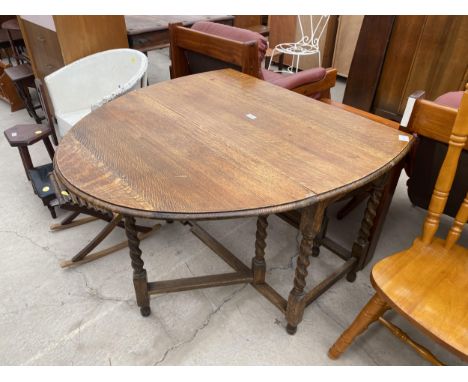AN EARLY 20TH CENTURY OVAL OAK GATE LEG DINING TABLE ON BARLEY TWIST SUPPORTS 