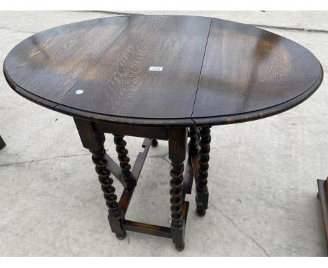 AN EARLY 20TH CENTURY OVAL OAK BARLEY-TWIST GATE-LEG TABLE 40 INCHES X 29 INCHES OPEN 