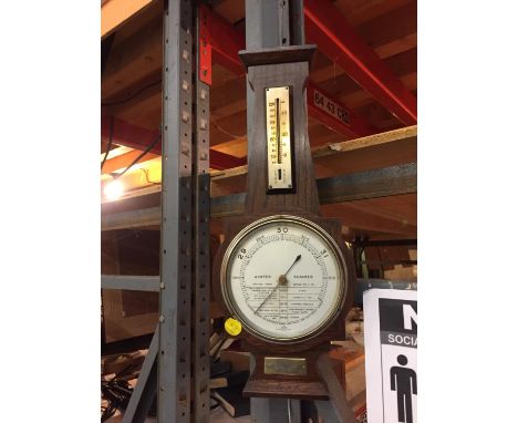 A VINTAGE WOODEN CASED BAROMETER WITH A PLAQUE WITH THE DATE 1949 ON IT. 