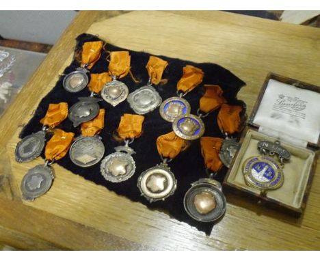 A collection of thirteen silver, silver-gilt and enamel fobs and medals, early 20th century; together with a cased enamel and