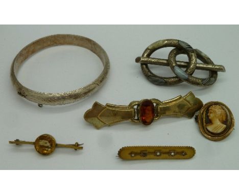 A silver bangle, vintage brooches including a Celtic hardstone brooch, lacking pin