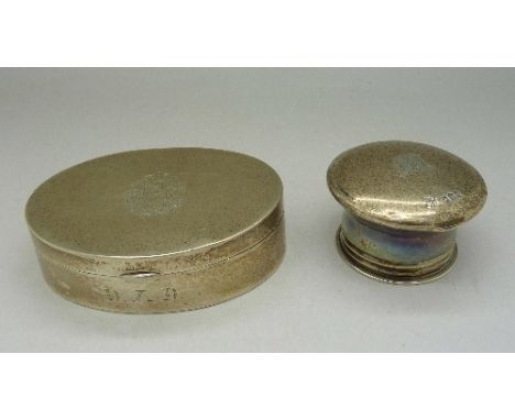 A white metal oval snuff box with inscription, hinge a/f, and a silver bottle top