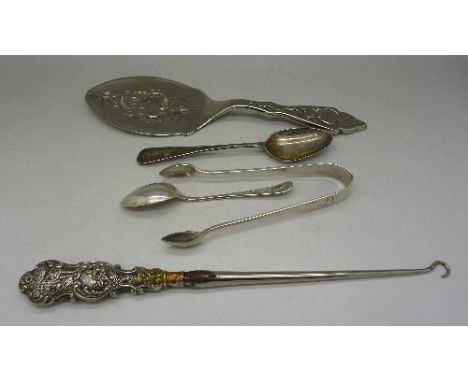 A pair of silver sugar bows, two silver spoons including Georgian, a silver handled button hook plus a plated cake slice