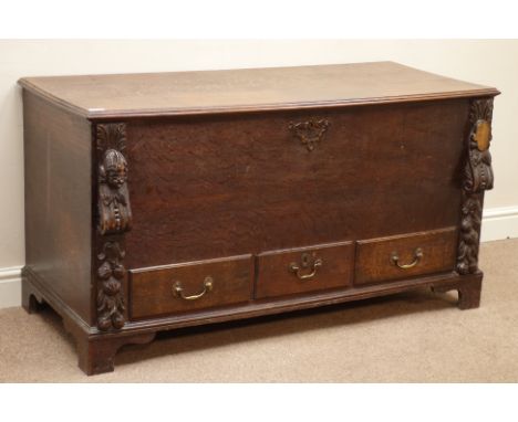 Early 19th century oak mule chest, hinged lid, with three drawers, carved foliate mounts and mask, bracket feet, W129cm, H69c
