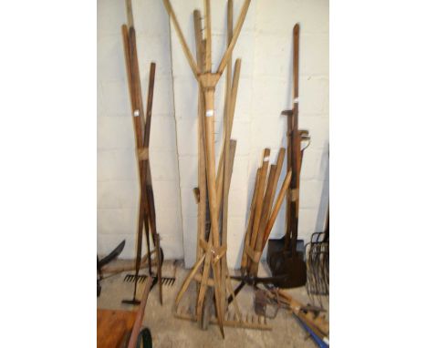 Bundle of various wooden handled hay forks, wooden rake and other tools, possibly for thatching
