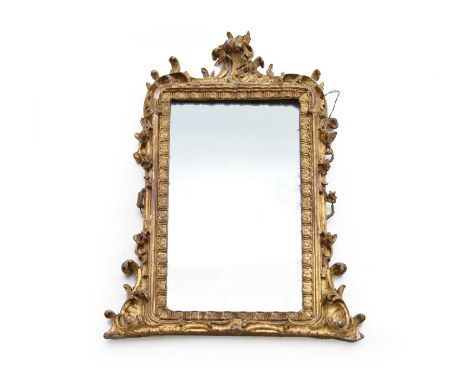 A rococo revival giltwood overmantel mirror, the rectangular plate within a triglyph-moulded sight, surrounded by scrolling f