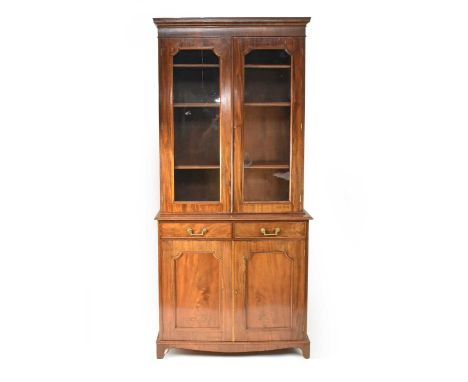 A George III mahogany bookcase cabinet, the upper section with cavetto cornice above twin glazed doors opening to adjustable 