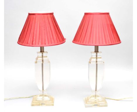 A pair of glass table lamps, contemporary, the clear glass of vase form with brushed steel fittings, fitted with pleated red 