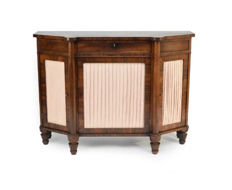 A 19th century rosewood credenza, of canted form, the shaped top above a beaded panel frieze with central drawer and three cu