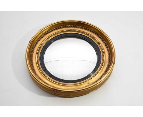 A 19th century giltwood convex mirror, of circular form, the convex plate within an ebonised reeded sight, the cavetto frame 