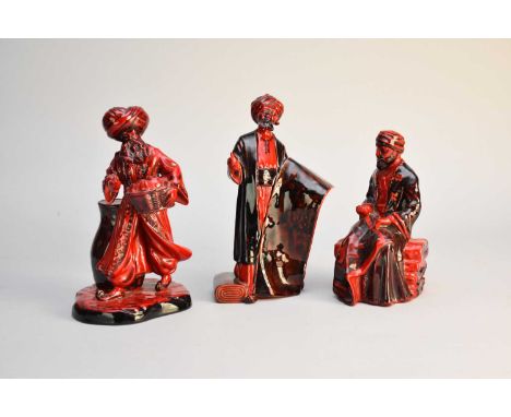 Three Royal Doulton flambe figures comprising 'Lamp seller' HN3278; 'Carpet Seller (seated)' HN3277 and 'Carpet Seller (stand