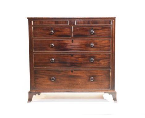An early 19th century mahogany chest of drawers, the plain top above two concealed frieze drawers and two short over three lo