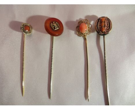 2x Vintage gold stick pins with coral heads; a gilt stickpin with a coral head and a silver stick pin with a Napoleonic eagle