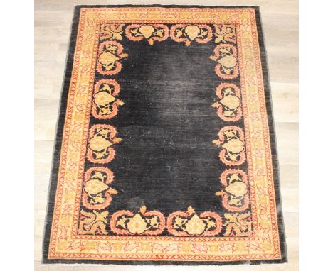 A vintage Afghan rug of black ground with decorative gold border, label verso marked Zigler, 192cm x 145cm
