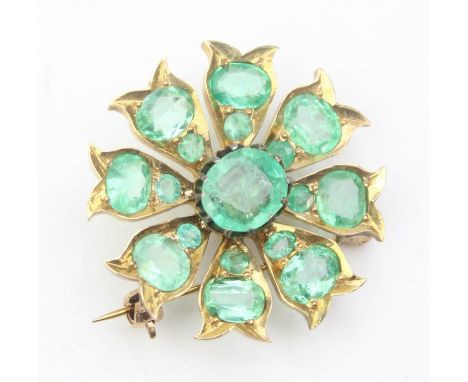 An antique brooch set with emeralds in a floral cluster, the metal unmarked but XRF testing around 10ct gold, likely American
