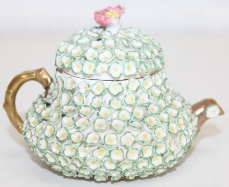 An extremely rare Rockingham squat pear shaped miniature teapot and cover, encrusted with florets and with floral knop, gilt 