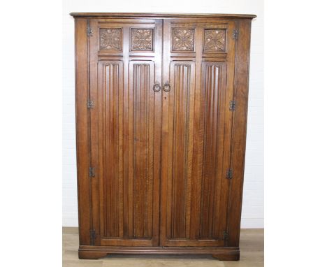 A Gothic style oak wardrobe with Linen fold panels, label for Crown AY furniture, 122cm x 58cm x 183cm