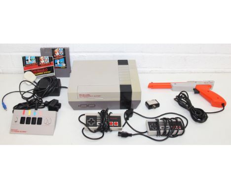 Vintage Nintendo Entertainment System (NES) games console with 2 control pads, Four Score adapter, Zapper, and Super Mario Br