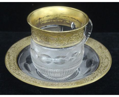 Moser of Karlsbad - an antique gilt rimmed and cut glass cup and saucer, marked to base Moser of Karlsbad, with cut decoratio